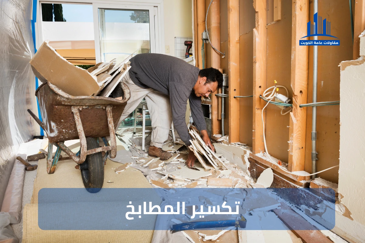 صورة توضح عمال تكسير مطابخ في موقع بناء داخل الكويت وهم يقومون بإزالة الخزائن والأدوات القديمة وتكسير السيراميك والأرضيات باستخدام معدات تكسير متخصصة مع وجود مخلفات بناء مرتبة في أكياس تمهيدًا لتجهيز المكان لأعمال التجديد الجديدة